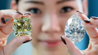 Una empleada de Christies muestra los dos diamantes.