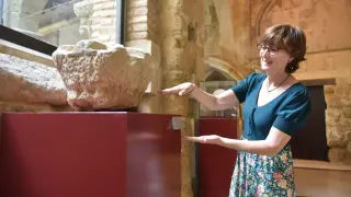 La arqueólogo Julia Justes, junto al capitel medieval hallado durante las excavaciones en el entorno de la catedral de Huesca.
