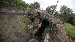 El soldado "Den" sale de una trinchera en un bosque de Ucrania el 3 de junio de 2022.