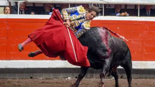 Cogida al diestro Roca Rey con el primero de los de su lote durante la corrida de la Feria de Bilbao celebrada este jueves en la plaza toros de Vistalegre.