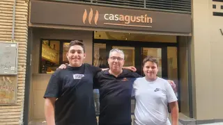 Antonio Miguel Serón, propietario de Casa Agustín, con sus hijos Agustín y David en la puerta del nuevo restaurante abierto en Zaragoza.