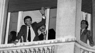 Felipe González y Alfonso Guerra saludan desde uno de los balcones del hotel Palace a los seguidores y simpatizantes del PSOE, tras conseguir el triunfo en las elecciones legislativas