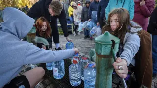 Varias personas llenan garrafas con agua de una fuente en Kiev.