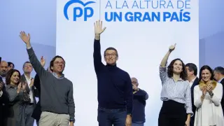 José Luis Martínez-Almeida, Alberto Núñez Feijóo e Isabel Díaz Ayuso saludan durante el acto de presentación de los candidatos del PP en Madrid, este domingo