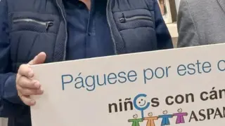El fotógrafo oscense Fernando Paúles entregando el cheque solidario de su empresa al gerente de Aspanoa, Juan Carlos Acín,