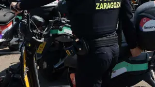 Un agente de la Policía Local de Zaragoza retira una de las motocicletas de Reby en el depósito, donde hay ya cerca de medio centenar