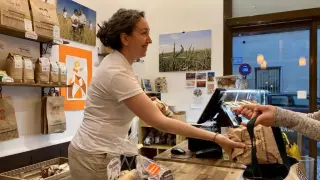 Laura Marcén, gerente de Ecomonegros, entrega a una clienta uno de los lotes.