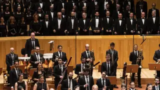 El coro Amici Musicae, arriba, y la Orquesta Reino de Aragón, durante el recital en el Auditorio de Zaragoza
