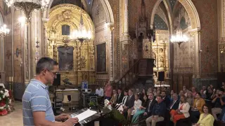 Un usuario de Atadi lee el pregón de las fiestas en una iglesia de San Pedro repleta de público.