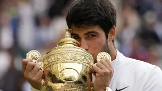 Spain's Carlos Alcaraz celebrates with the trophy after beating Serbia's Novak Djokovic to win the final of the men's singles on day fourteen of the Wimbledon tennis championships in London, Sunday, July 16, 2023. (AP Photo/Kirsty Wigglesworth)