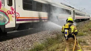 Bomberos de la Diputación de Huesca sofocando el incendio de un tren de la línea Zaragoza-Lérida.