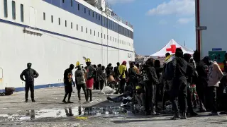 Un grupo de inmigrantes espera en la isla de Lampedusa mientras las autoridades italianas se preparan para trasladar a las personas tras las nuevas llegadas, en Italia.