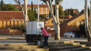 Vecina de Tarazona, este lunes, recoge agua de un tanque en el parquin de Eguarás