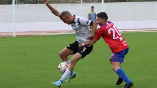 Un jugador del Calatayud disputa un balón ante la presión del Mallén