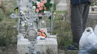 Dos personas colocan sus flores en una lápida del cementerio de Torrero, este sábado.
