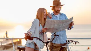 atractiva-pareja-feliz-viajando-verano-bicicleta-hombre-mujer-cabello-rubio-boho-hipster-estilo-moda-divirtiendose-juntos-mirando-mapa-turismo