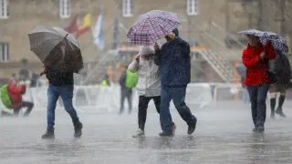 SANTIAGO DE COMPOSTELA, 28/10/2023.- Turistas bajo la lluvia este sábado en la plaza del Obradoiro en Santiago de Compostela. La AEMET lanza un aviso naranja en la costa coruñesa, y toda la comunidad esta bajo una borrasca con fuertes lluvias y viento.- EFE/Lavandeira jr