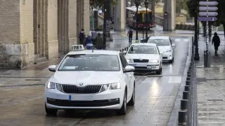 Varios de los taxis de Zaragoza, a su paso por la calle de Don Jaime I