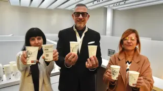 Sheila Enfadaque, diseñadora, junto a Raúl Benito, presidente de Eboca, y Obarra Nagore, responsable de exposiciones y colecciones del CDAN de Huesca, muestran los vasos de café ilustrados.