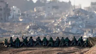 Soldados israelíes apostados en una colina en el norte de Gaza desde donde observan una zona reducida a escombros.
