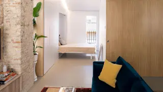 Una vivienda de Zaragoza donde la cama se esconde en la pared para transformar una pequeña sala de reunión en un dormitorio.