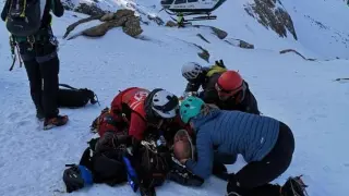 Momento en que una médico del 061 y socorristas del Greim atienden al montañero vasco accidentado en el Aspe.