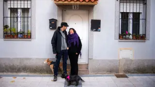 Lorena, su pareja Juan y su perra frente a la puerta de su casa