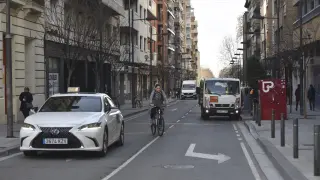 Taxis, bicis, transporte de carga y descarga, vehículos particulares y peatones conviven en la calle Zaragoza de Huesca.
