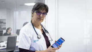 La doctora Amelia Cantarero muestra en su teléfono móvil la 'app' diseñada para mejorar la salud de los camioneros.