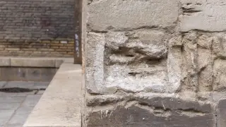 Tras retirar la inscripción del muro de la Seo, aún quedaba un rastro blanco del yeso empleado para fijarla a la piedra.