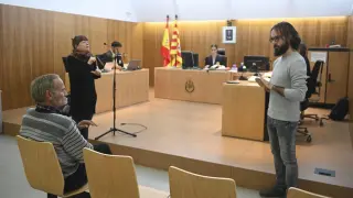 Santiago Asín, sentado, siguiendo las explicaciones de los dos intérpretes durante el juicio celebrado en el Juzgado de lo Penal de Huesca.