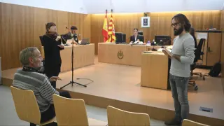 Santiago Asín, sentado, siguiendo las explicaciones de los dos intérpretes durante el juicio celebrado en el Juzgado de lo Penal de Huesca.