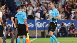 Galech Apezteguía, árbitro navarro, lleva una botella de plástico al delegado de campo en el partido Real Zaragoza-Mirandés (0-1) de la primera vuelta.
