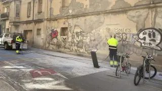 Brigadas limpiando grafitis en la calle Alcalde Carderera de Huesca.