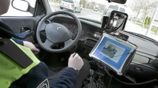 Foto de archivo de un policía controlando el exceso de velocidad desde un coche camuflado.
