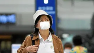 Una viajera con mascarilla, en el aeropuerto de Pekín