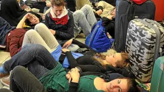 Un grupo de italianas esperan en el aeropuerto de Berlín tras cancelarse su vuelo a Venecia.
