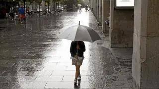 Una niña paseaba ayer cubierta con un paraguas por el paseo de la Independencia de Zaragoza.