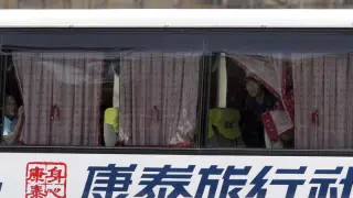 Varios rehenes miran por la ventana del autobús.