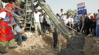 Varios israelíes trabajan en una obras del asentamiento Kiryat Netafim, ayer en Cisjordania.