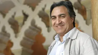 José Luis Corral sonríe en un rincón de la historia aragonesa, en la Aljafería.