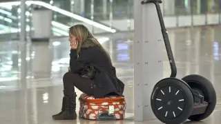 Una joven espera en el aeropuerto de Barcelona que se reanuden los vuelos