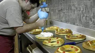 Luis Paracuellos, de la pastelería El Capricho, le añade la nata a uno de los roscones.