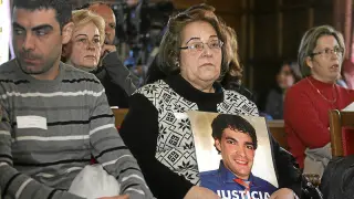 Julia Bernad, sentada entre el público, abraza la foto de su hijo en la que pide Justicia.