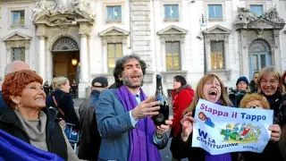 Miembros del movimiento Violeta anti-Berlusconi celebran en la calle la decisión del Tribunal Constitucional, ayer en Roma.