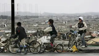 Alumnos de la escuela Omagari montan en bicicleta entre los escombros en Higashimatsushima, prefectura de Miyagi