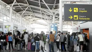 Grupos de pasajeros de líneas 'low cost' esperan en el aeropuerto de Zaragoza para embarcar.
