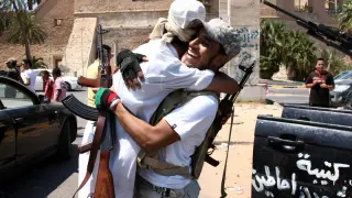 Dos de los opositores se abrazan celebrando el avance rebelde