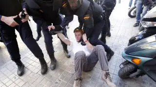 La policía custodia a un manifestante durante las protestas de Valencia.