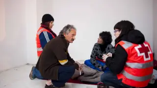 Voluntarios de la Cruz Roja ayudan a un sintecho